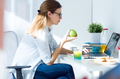 Pretty Young Woman Eating An Apple And Working At Home by nenetus
